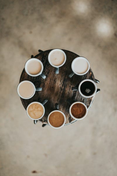 Too Many Options Shown As Eight Coffees in Mugs on Round Table