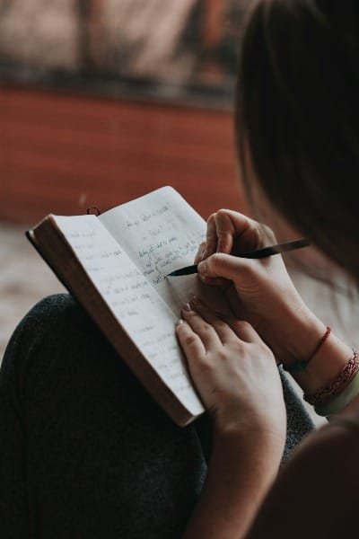 A person writing goals in a notebook